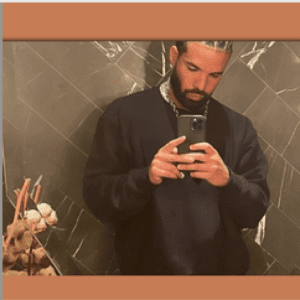 A man wearing a black sweater takes a mirror selfie with his smartphone in a tiled bathroom, contemplating productivity. He's surrounded by decorative items on the counter, and the photo is elegantly framed with a brown border, embodying the "Mind My Business" ethos.